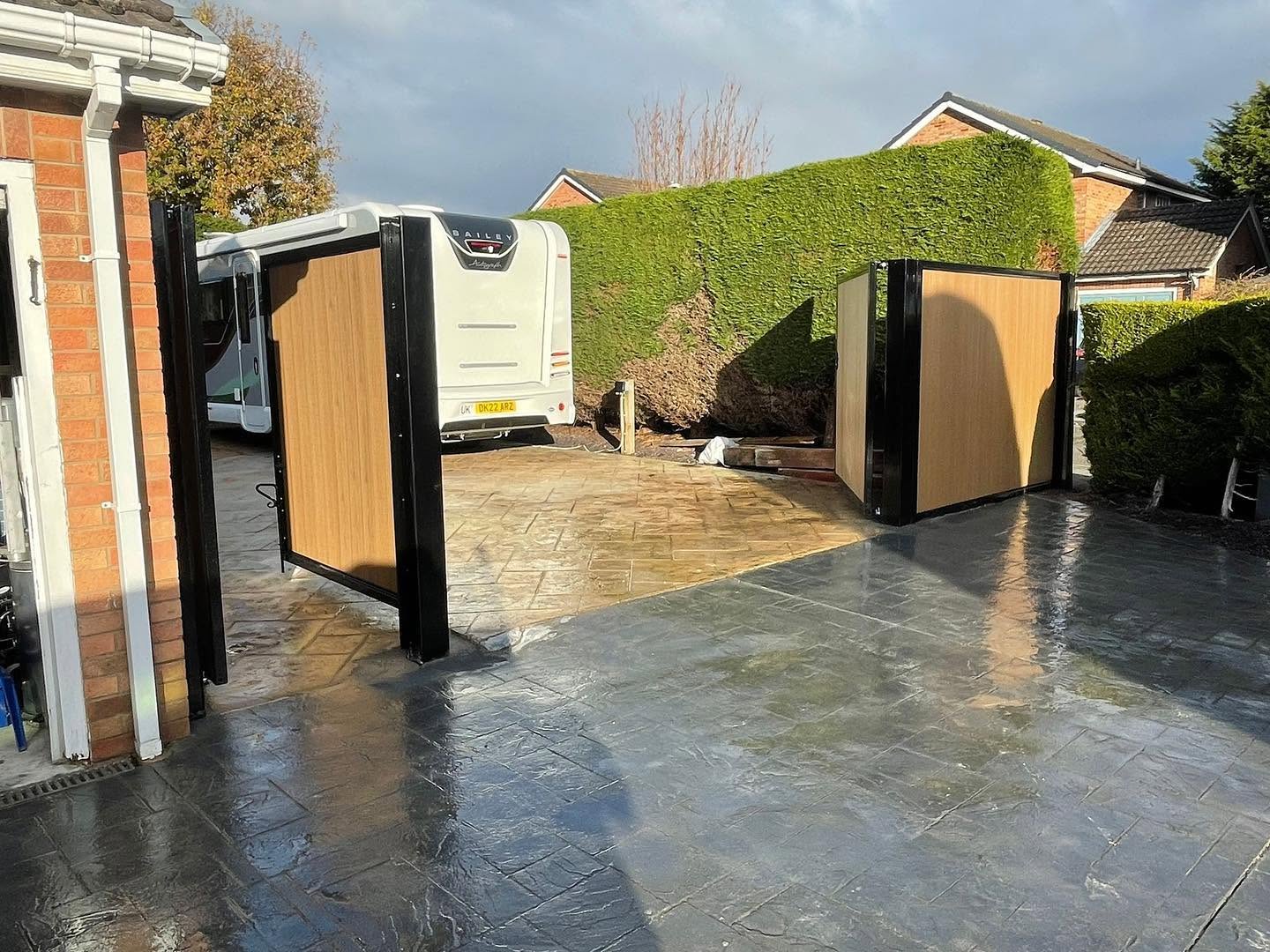 Matching composite driveway and pedestrian gates shown open